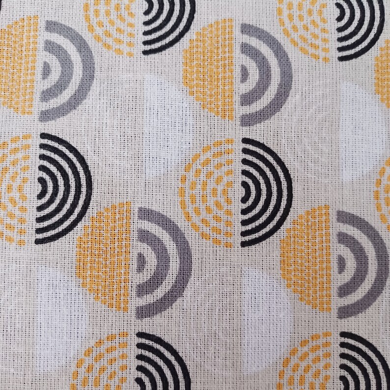 May include: White fabric with a repeating pattern of yellow, grey, and black semi-circles. The semi-circles are made up of concentric circles and dots.
