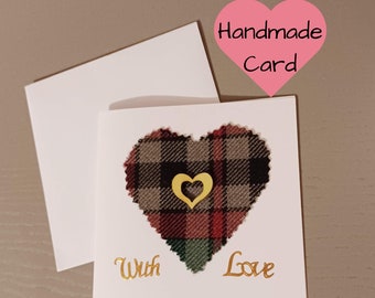 Puede incluir: Tarjeta hecha a mano con un corazón de cuadros y letras doradas que dicen "With Love".