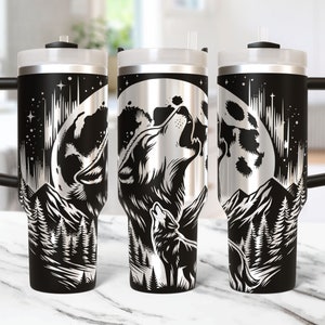 May include: Three stainless steel tumblers with a black and silver design of a wolf howling at the moon. The design also includes a mountain range and trees.