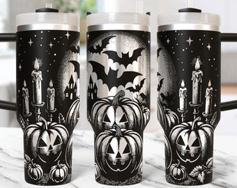 May include: Black and silver Halloween-themed tumbler with a handle. The design features jack-o'-lanterns, bats, a full moon, candles, and a haunted house. The tumbler has a black handle and a clear lid with a straw.