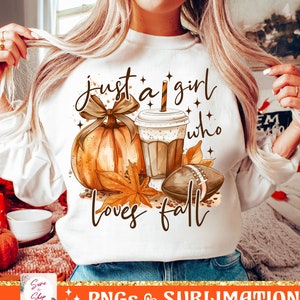 Puede incluir: Sudadera blanca con el texto "Just a girl who loves fall" en letras marrones. El diseño incluye una calabaza, una taza de café y una pelota de fútbol.