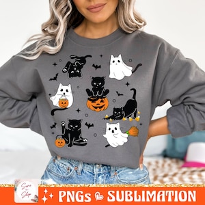 以下が含まれることがあります： 黒猫と幽霊が描かれたグレーのトレーナー。ハロウィンをテーマにしたデザインで、猫はコスチュームを着て、カボチャとキャンディーコーンを持っています。幽霊は魔女の帽子をかぶり、ほうきを持っています。