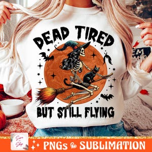 May include: White sweatshirt with a graphic of a skeleton witch riding a broomstick with a black cat. The text "Dead Tired But Still Flying" is printed on the shirt.