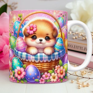 May include: A white ceramic mug featuring a pink, purple and blue Easter-themed design. A cartoon puppy with brown fur and a pink flower on its head is sitting in a wicker basket filled with colourful Easter eggs. The mug has a white handle.