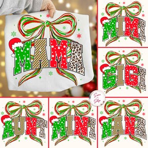 Puede incluir: Sudadera blanca con la palabra "MAMA" en letras verdes, rojas y con estampado de leopardo, adornada con un lazo navideño y un gorro de Papá Noel. Otros diseños incluyen "MIMI", "GIGI", "AUNT", "MINI" y "NANA".