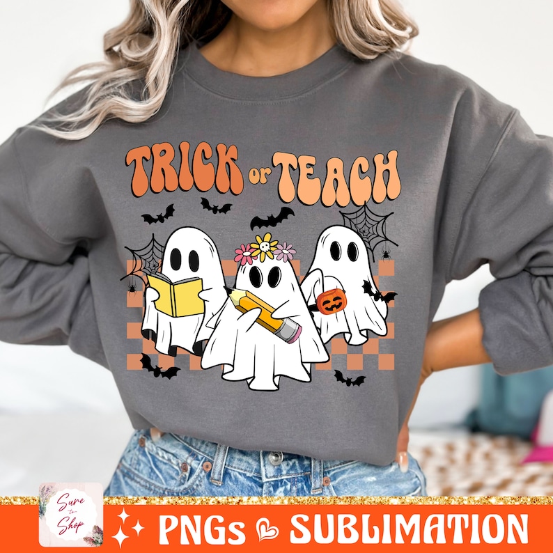 May include: A grey sweatshirt with the text "Trick or Teach" in a retro font. Three ghosts are depicted, one holding a book, one holding a pencil, and one holding a pumpkin.