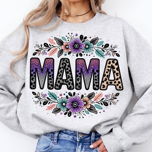 May include: A grey sweatshirt with a floral design and the word "MAMA" in black with a leopard print pattern.