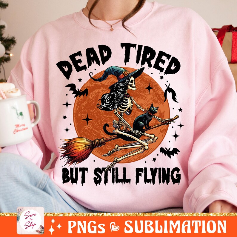May include: Pink sweatshirt with a graphic of a skeleton witch riding a broomstick with a black cat. The text reads "Dead Tired But Still Flying".