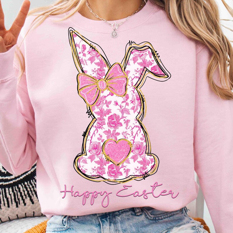 Op de afbeelding: Roze sweatshirt met een bloemig konijnontwerp en de tekst "Happy Easter" in gouden letters.