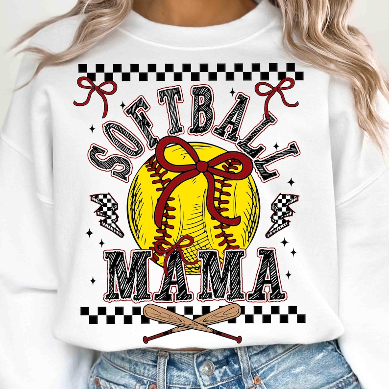 May include: White sweatshirt with a softball graphic. The design features a yellow softball with red stitching and a red bow, the words "SOFTBALL MAMA" in black and red, and crossed baseball bats.