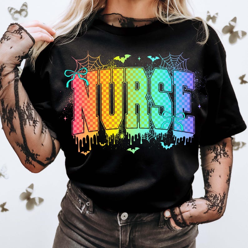 Pu&ograve; includere: T-shirt nera con la scritta "NURSE" in lettere a scacchi arcobaleno. Il design include ragnatele, pipistrelli e vernice che gocciola, creando un tema di Halloween. La maglietta ha uno scollo tondo.