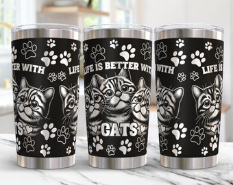 Puede incluir: Tres vasos de acero inoxidable con huellas de patas blancas y negras y el texto "La vida es mejor con gatos".