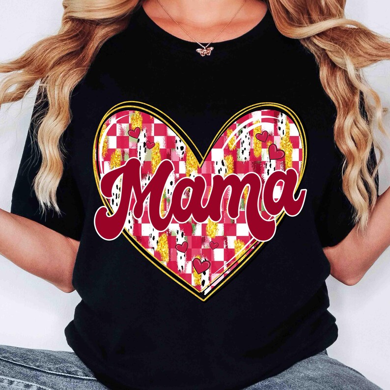 K&ouml;nnte beinhalten: Schwarzes T-Shirt mit einem herzf&ouml;rmigen Design. Das Herz hat ein rot-wei&szlig;es Karomuster, goldene Akzente und kleine rote Herzen. Das Wort "Mama" ist in roter Schrift &uuml;ber dem Herzen geschrieben.