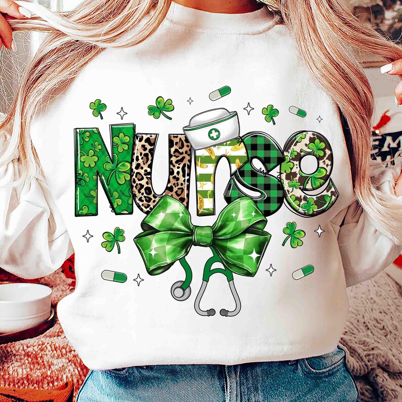 Pu&ograve; includere: Felpa bianca con la scritta "Nurse" in un design decorativo. Le lettere sono decorate con trifogli, stampa leopardata e motivi a quadri verdi e neri. Sono inclusi anche un fiocco verde e uno stetoscopio.