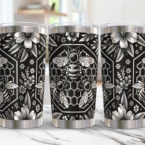May include: Three stainless steel tumblers with a black and silver design featuring bees, honeycombs, and floral patterns.