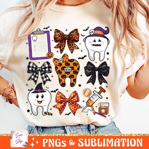 May include: A white t-shirt with a Halloween-themed dental design. The design features a tooth with a witch's hat, a tooth with a bow, a dental chart, a tooth with a pumpkin, a bow with black and white polka dots, a bow with orange and black polka dots, a dental floss container, a dental mirror, and a syringe.