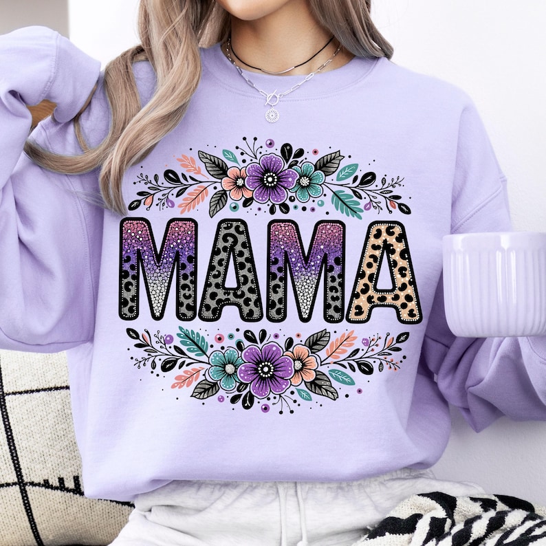 May include: Purple sweatshirt featuring a floral design and the word "MAMA" in a glittery, leopard print font.