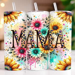 May include: A white tumbler with a straw, featuring a watercolor design of sunflowers, pink and blue flowers, and green leaves. The word "MAMA" is written in gold letters with a leopard print pattern.
