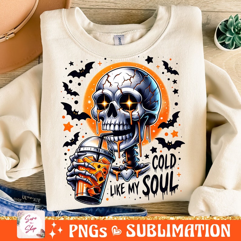May include: A white sweatshirt with a graphic of a skeleton drinking a cold beverage. The skeleton has glowing eyes and is dripping with a golden liquid. The text on the sweatshirt reads "Cold Like My Soul".