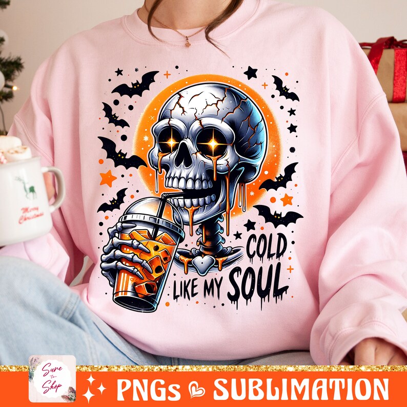 May include: A pink sweatshirt with a graphic of a skeleton drinking a cold beverage. The skeleton is dripping with a yellow liquid and has glowing eyes. The text on the sweatshirt reads "Cold Like My Soul".
