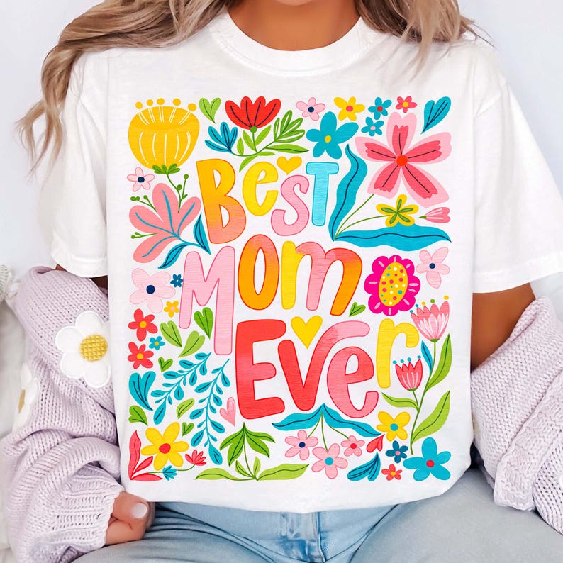 May include: White t-shirt with a colorful floral design and the text "Best Mom Ever" in a rainbow gradient.