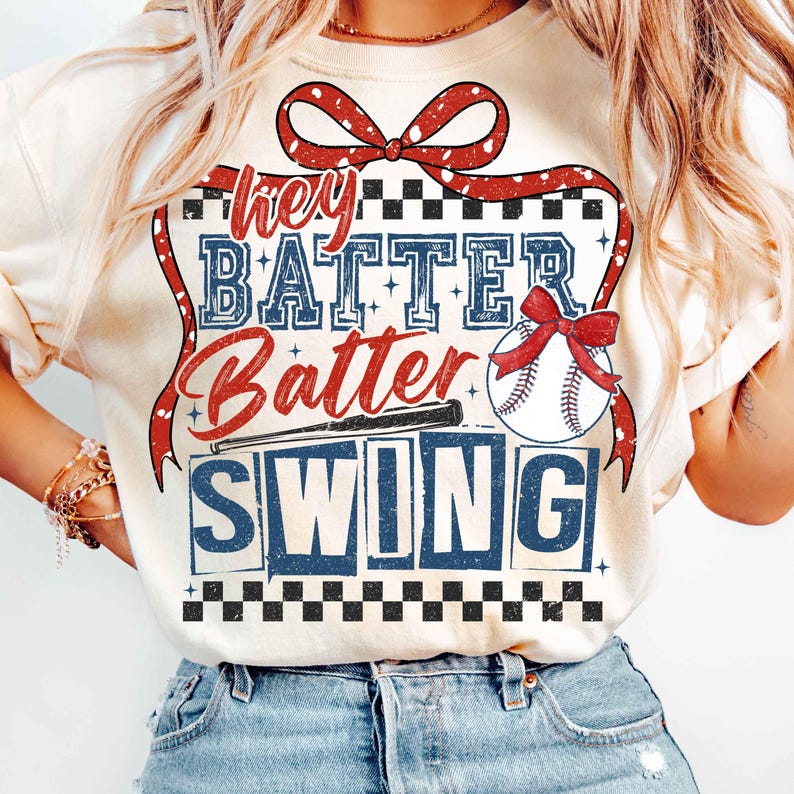 May include: A white t-shirt with a red, white, and blue baseball-themed graphic. The graphic says "Hey Batter Batter Swing" with a baseball and bat.