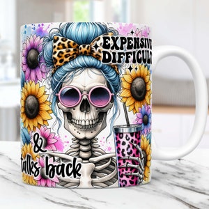 May include: White ceramic mug with a colorful design featuring a skeleton with blue hair, sunglasses, and a leopard print bow. The skeleton is holding a pink and leopard print cup with a straw. The mug has the text "Expensive, Difficult & talks back" printed on it.