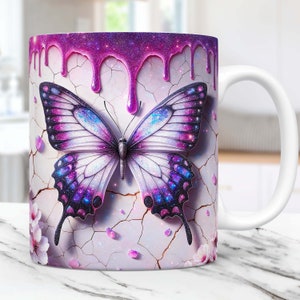 May include: White ceramic mug featuring a purple glitter butterfly design. The butterfly has iridescent wings and is surrounded by pink flowers and purple glitter drips.