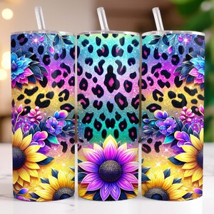 May include: Three stainless steel tumblers with lids and straws. The tumblers feature a colorful design with a leopard print, sunflowers, and other flowers. The background is a glittery gold.