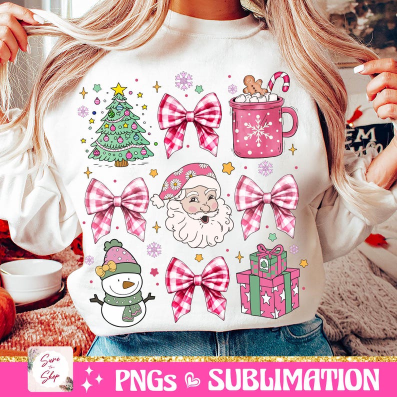 May include: White sweatshirt with a pink and white Christmas design. The design includes a Christmas tree, Santa Claus, a snowman, presents, bows, and a mug of hot chocolate.