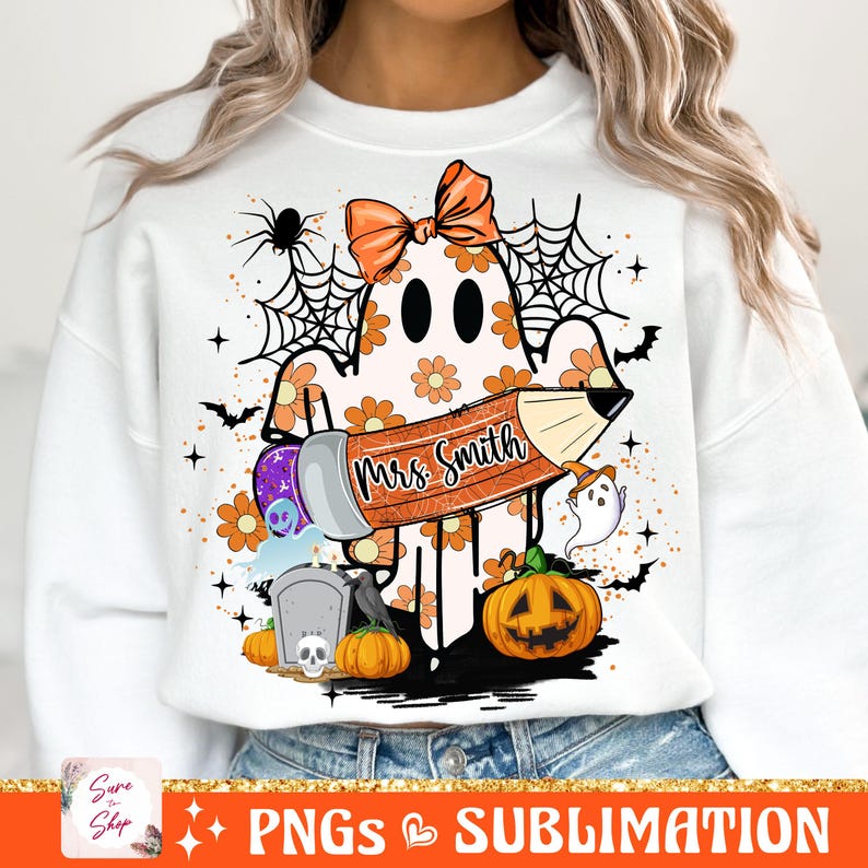 Puede incluir: Una sudadera blanca con un fantasma que lleva un lazo y sostiene un l&aacute;piz que dice "Mrs. Smith". El fantasma est&aacute; rodeado de im&aacute;genes de tem&aacute;tica de Halloween, incluyendo calabazas, murci&eacute;lagos y telara&ntilde;as.