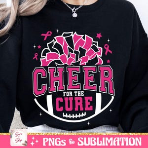 May include: Black sweatshirt with a pink and white design. The design features a cheerleading pom-pom, a football, and the text "Cheer for the Cure".