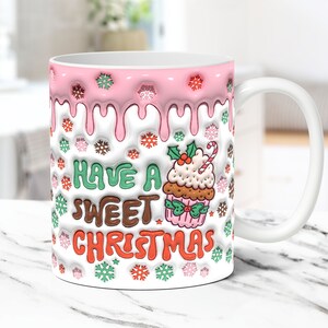 May include: White ceramic mug with a pink and white frosting design. The mug has a cupcake with a candy cane and the text "Have a Sweet Christmas" on it.