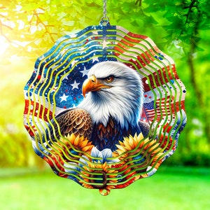 May include: A metal wind spinner with a red, white, and blue American flag design. The spinner features a bald eagle with sunflowers and a swirling pattern.