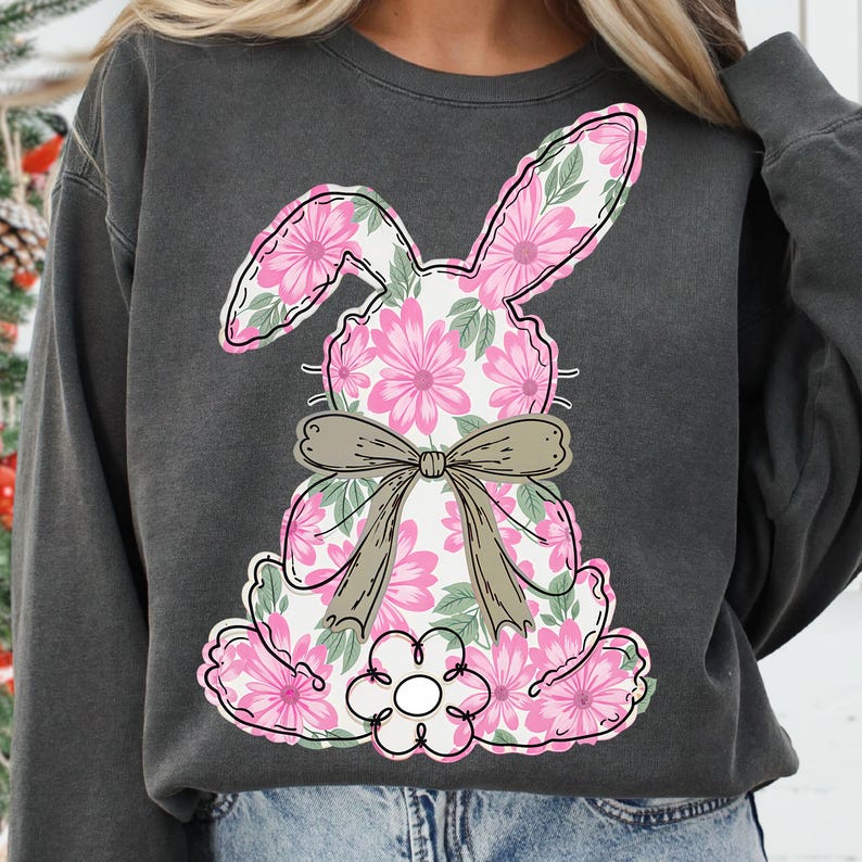 May include: A gray sweatshirt with a pink floral bunny design. The bunny has a brown bow and is sitting on a white background.