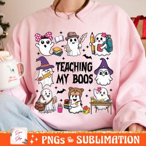 May include: Pink sweatshirt with a graphic of ghosts and the text "Teaching My Boos". The ghosts are dressed as students with books, pencils, and backpacks.