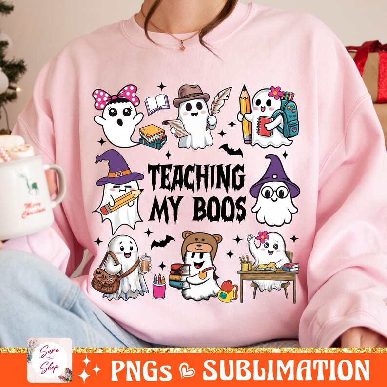 May include: Pink sweatshirt with a graphic of ghosts and the text "Teaching My Boos". The ghosts are dressed as students with books, pencils, and backpacks.
