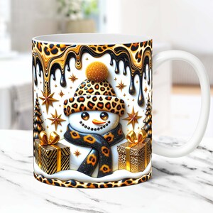 May include: White ceramic mug with a snowman design. The snowman is wearing a leopard print hat and scarf. The background is a gold and black leopard print with dripping gold paint.