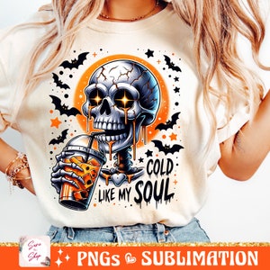 May include: A white t-shirt with a graphic of a cartoon skeleton holding a cold drink. The skeleton has glowing eyes and is dripping with orange liquid. The text "Cold Like My Soul" is written below the skeleton.