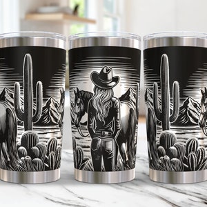 May include: Three stainless steel tumblers featuring a black and white design of a woman in a cowboy hat standing in front of a horse and a cactus in a desert landscape.