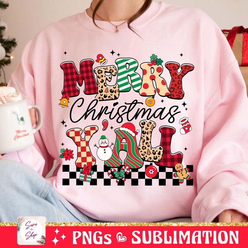 Pu&ograve; includere: Felpa rosa con un design natalizio festoso che presenta il testo "Merry Christmas Y'all" in lettere colorate e decorate. Il design include un pupazzo di neve, bastoncini di zucchero e un omino di pan di zenzero.
