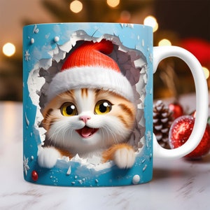 Peut inclure: Une tasse en c&eacute;ramique blanche avec un motif bleu et blanc. Un chat de dessin anim&eacute; portant un bonnet de P&egrave;re No&euml;l rouge et blanc sort d'un trou dans la tasse. Le chat a du pelage orange et blanc et de grands yeux bleus.