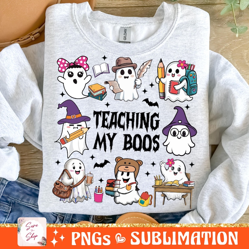 May include: A gray sweatshirt with a design of ghosts dressed as teachers. The text "TEACHING MY BOOS" is printed on the sweatshirt.