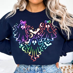 May include: A navy blue sweatshirt with a rainbow-colored design of three ghosts with bows, bats, and stars.