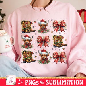 May include: Pink sweatshirt with a Christmas design featuring a Highland cow wearing a Santa hat, a red bow, and cowboy boots. The design is repeated multiple times on the sweatshirt.