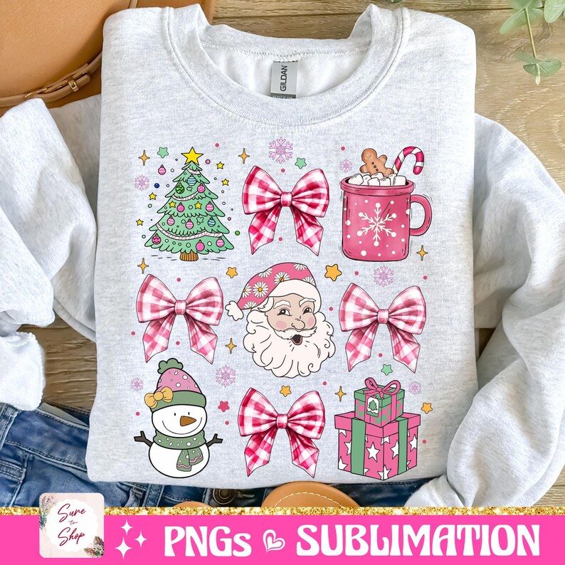 May include: A gray sweatshirt with a Christmas design featuring a green Christmas tree, Santa Claus, a snowman, a mug of hot chocolate, a gift box, and pink and white gingham bows.