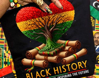 May include: Black t-shirt featuring a heart-shaped tree in red, yellow, and green, with scrolls at the base. The words "BLACK HISTORY" and "HONORING THE PAST, INSPIRING THE FUTURE" are printed in white and red.