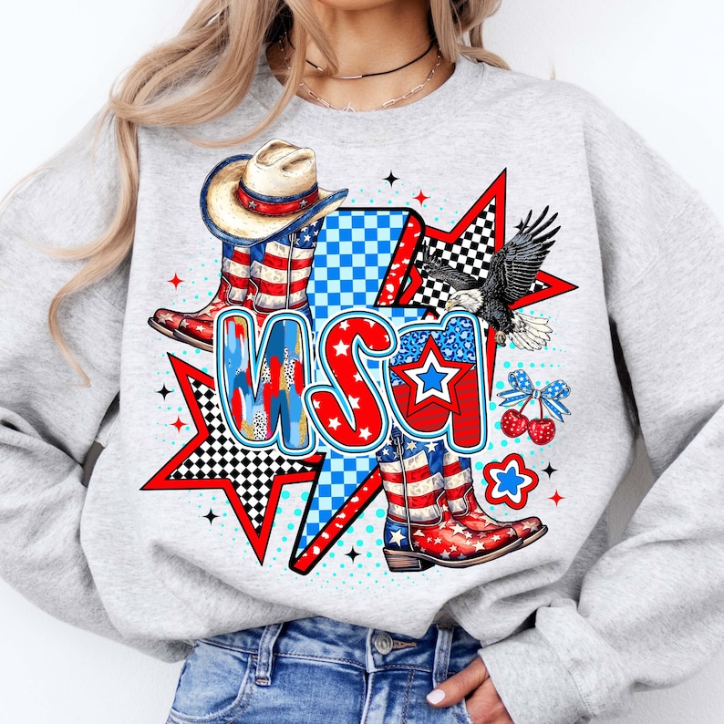 May include: Gray sweatshirt with a graphic print of a cowboy hat, boots, and an eagle with the word "USA" in red, white, and blue.