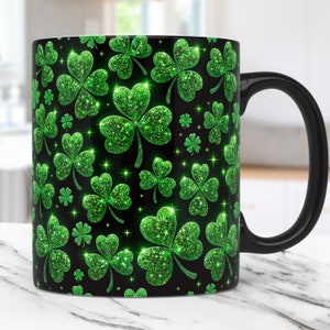 May include: Black coffee mug with a green glitter shamrock pattern.