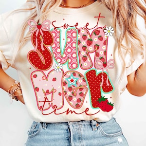 Pu&ograve; includere: Una maglietta bianca con una grafica rossa, rosa e verde che dice "Sweet Summer Time" con fragole e fiori.